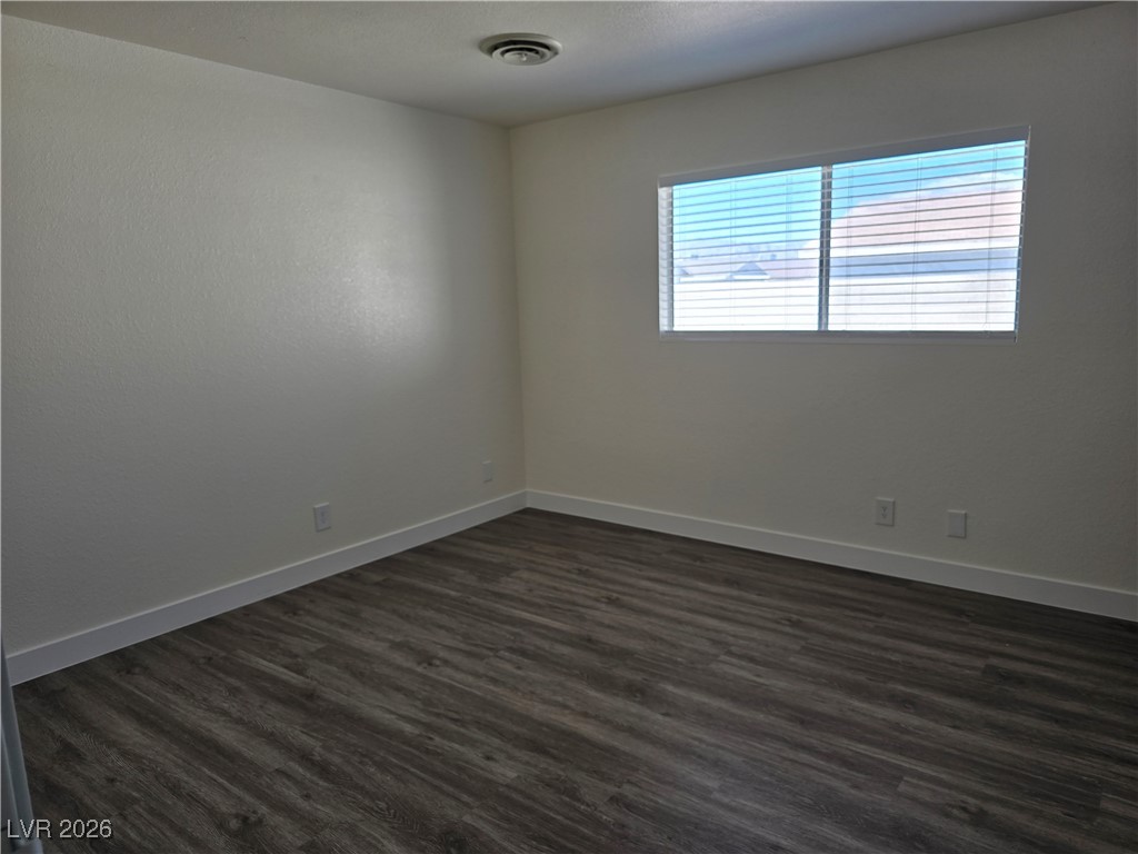 4219 Studio Street Las Vegas, NV 89115 - Photo 9 of 33 Empty room featuring dark wood-style floors and baseboards