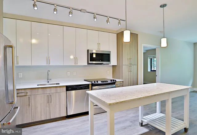 a kitchen with a sink a microwave and cabinets