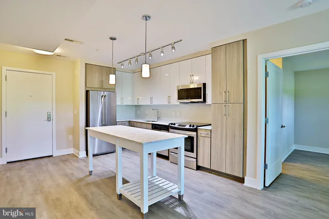 a kitchen with stainless steel appliances a stove a refrigerator sink and microwave