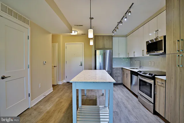 a kitchen with stainless steel appliances a stove a refrigerator and a oven