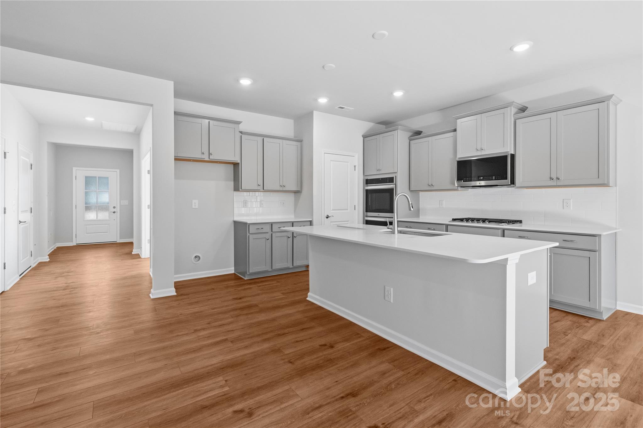 3322 Amarillo Court Lancaster, SC 29720 - Photo 15 of 30 a kitchen with stainless steel appliances granite countertop a stove top oven a sink and white cabinets