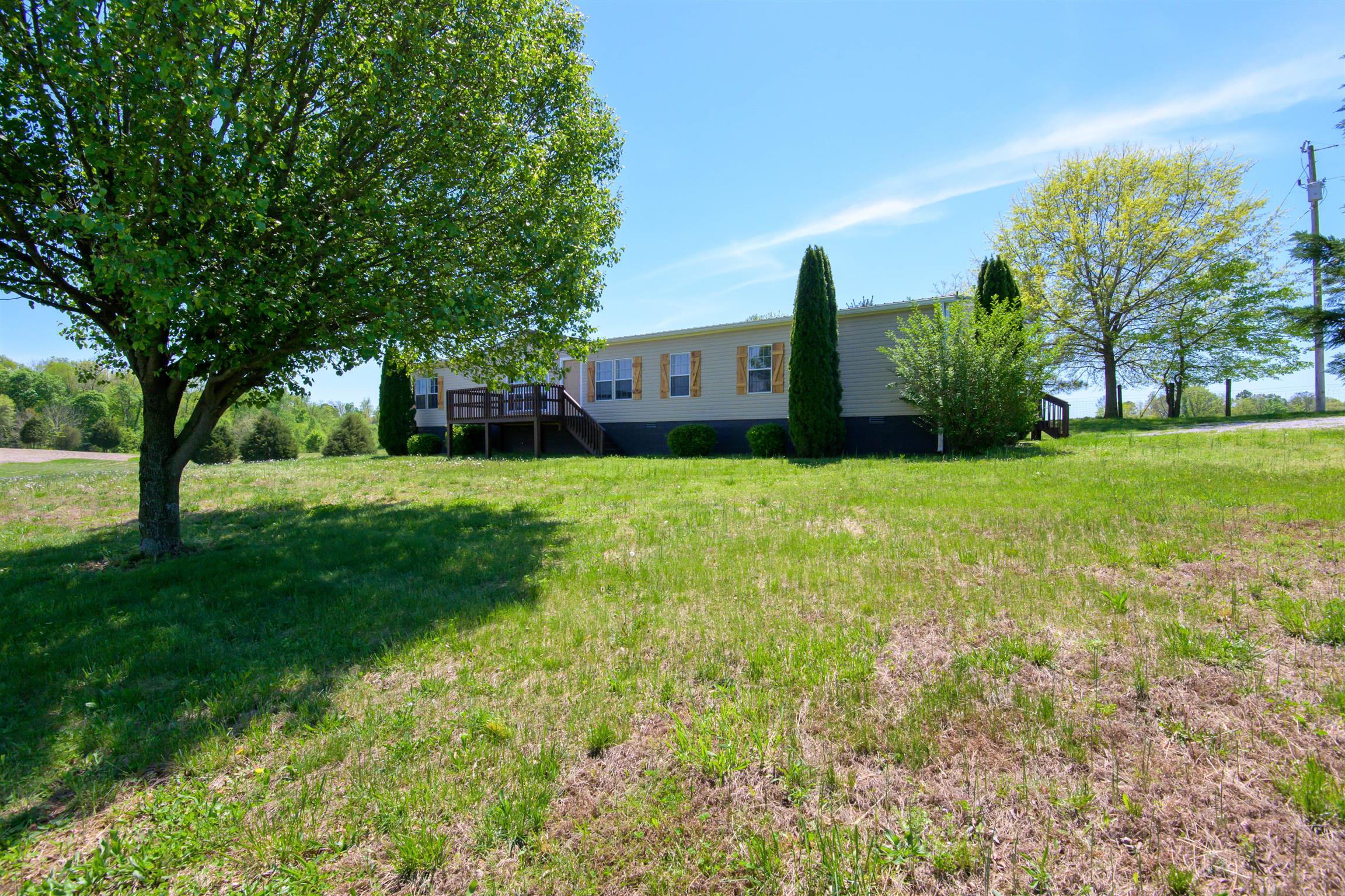 4489 Goodman Road Adams, TN 37010 - Photo 2 of 30 a view of a garden with a house in the background