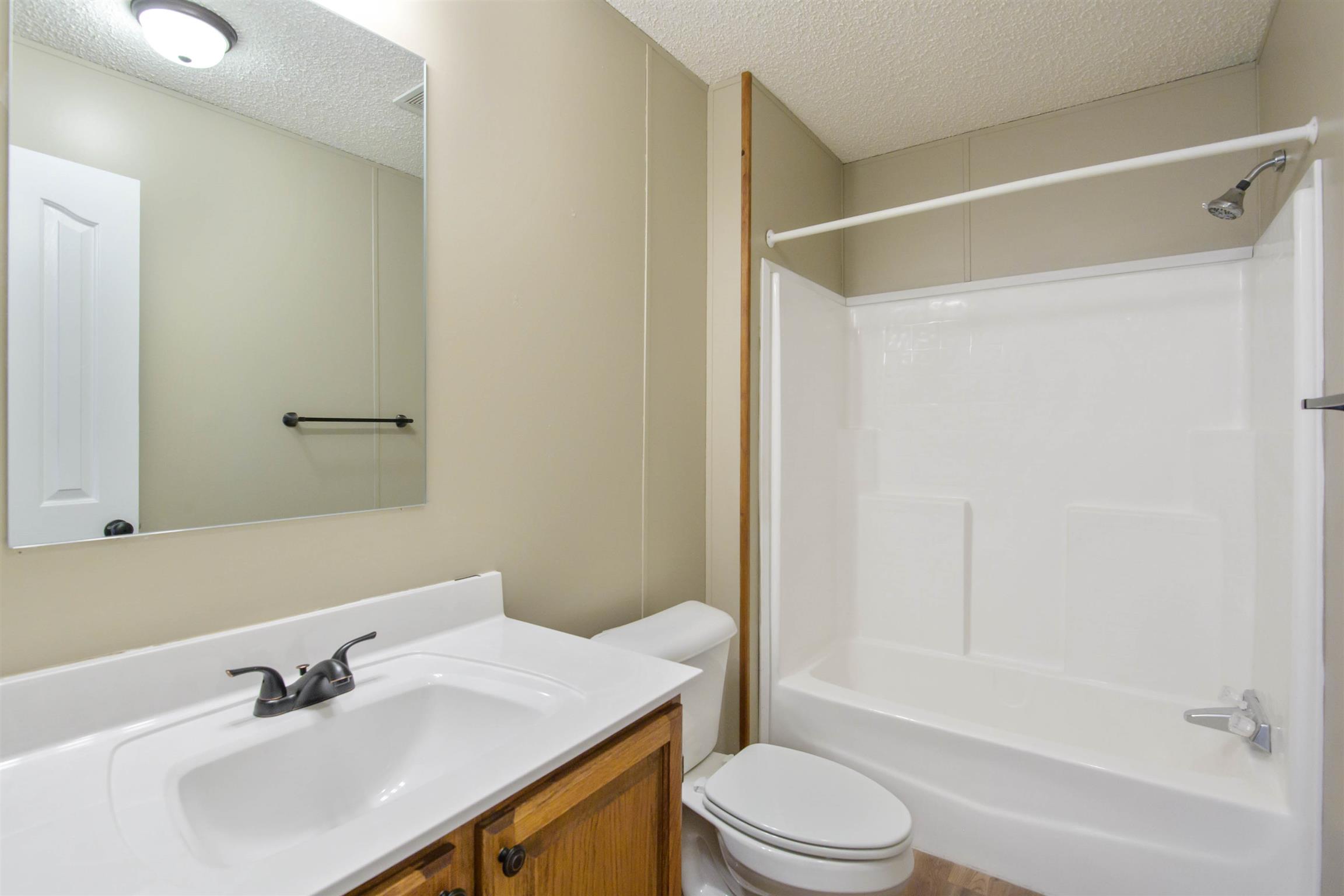 4489 Goodman Road Adams, TN 37010 - Photo 13 of 30 a bathroom with a sink toilet and shower