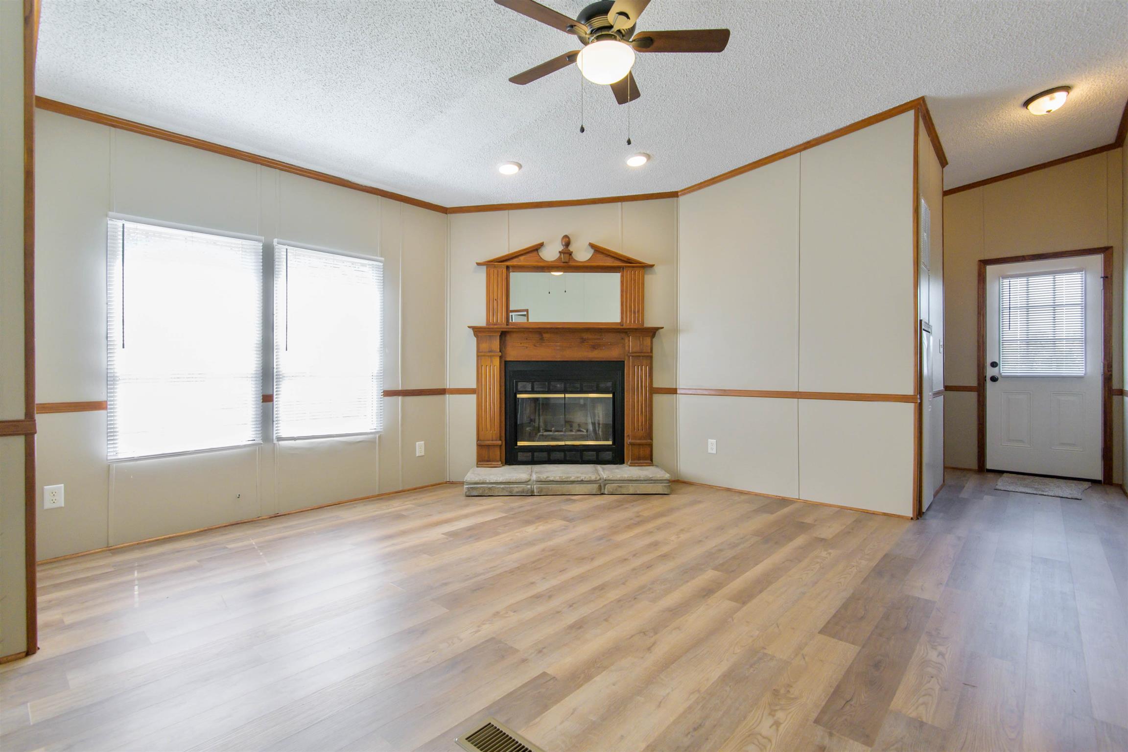 4489 Goodman Road Adams, TN 37010 - Photo 6 of 30 an empty room with windows and a fireplace