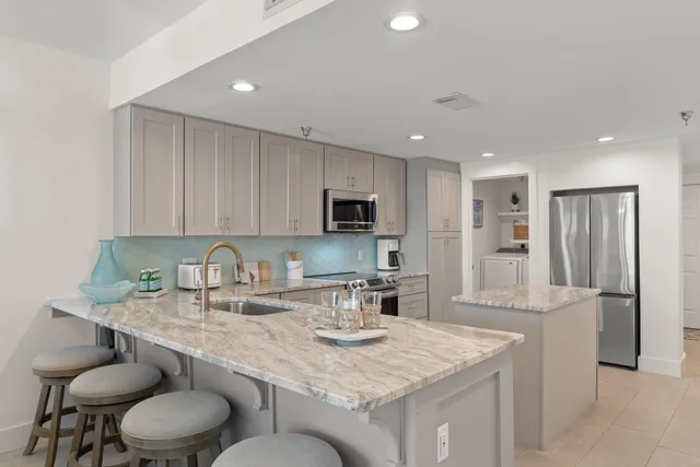 a kitchen with stainless steel appliances granite countertop a sink and a refrigerator