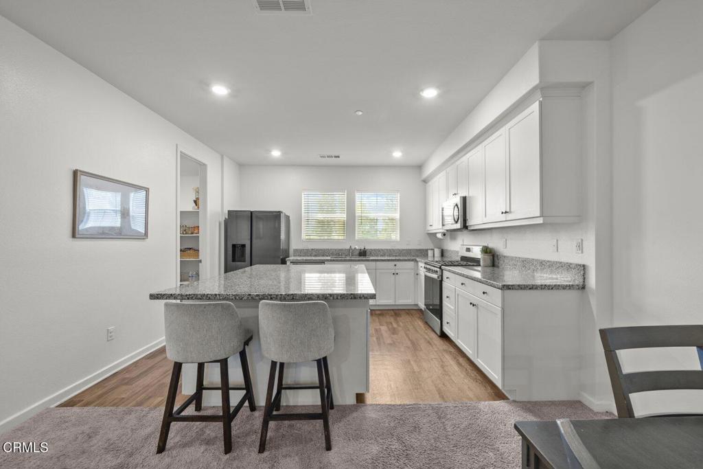 586 Apricot Lane Fillmore, CA 93015 - Photo 6 of 38 a kitchen with white cabinets and chairs