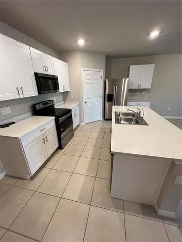 a kitchen with a sink a counter top space cabinets and stainless steel appliances