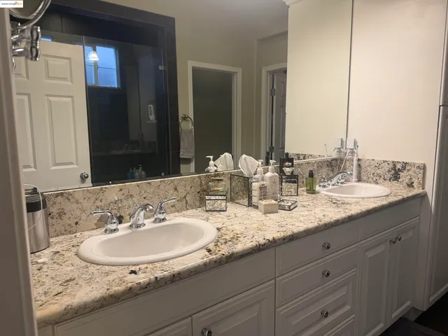 a bathroom with double sink and a mirror