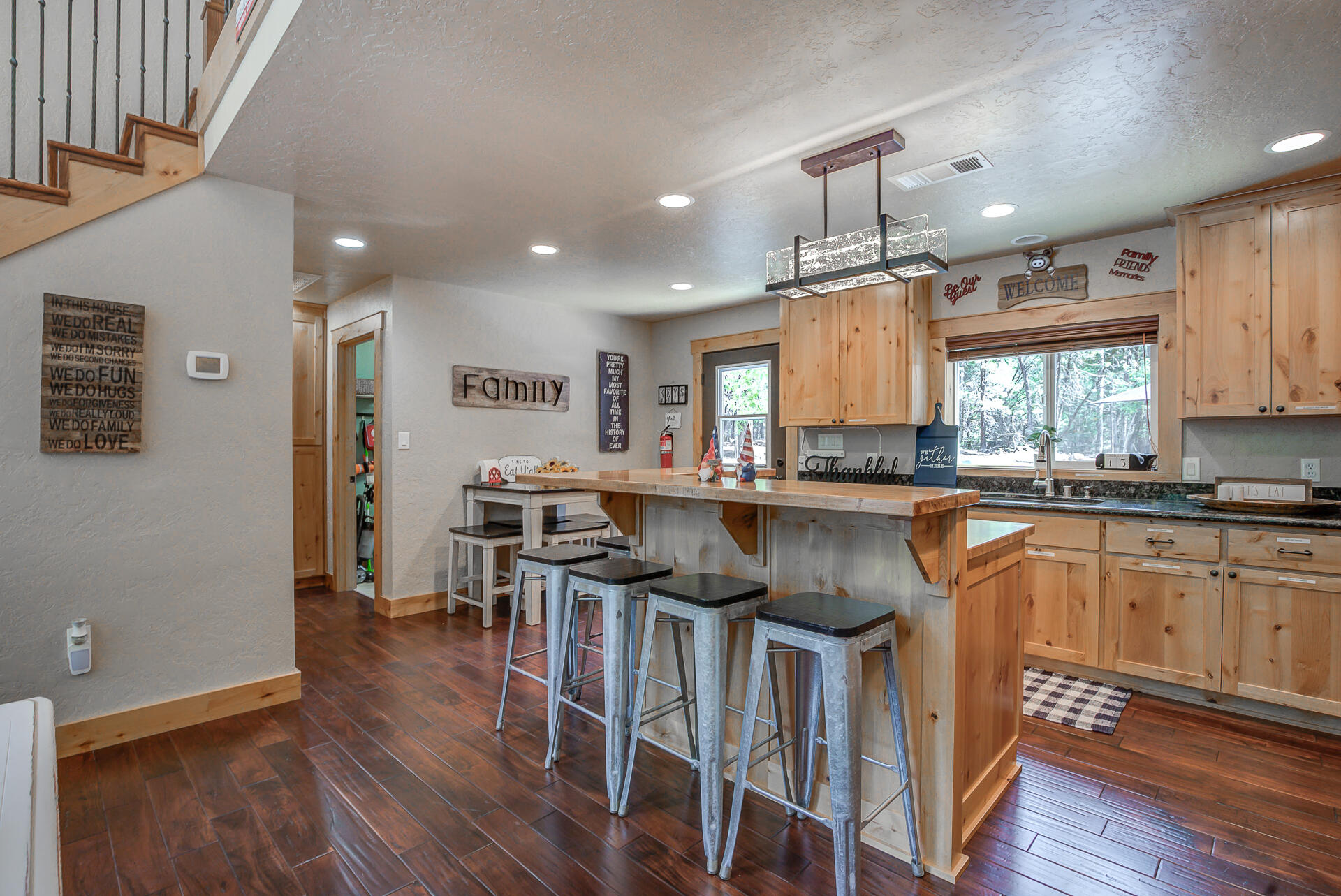 34607 Mountain Haven Road Shingletown, CA 96088 - Photo 12 of 63 a kitchen with stainless steel appliances granite countertop a refrigerator a stove top oven a sink dishwasher and white cabinets with wooden floor