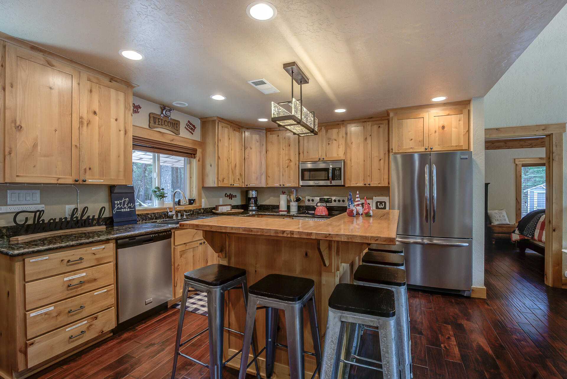 34607 Mountain Haven Road Shingletown, CA 96088 - Photo 14 of 63 a kitchen with kitchen island granite countertop wooden floors and refrigerator