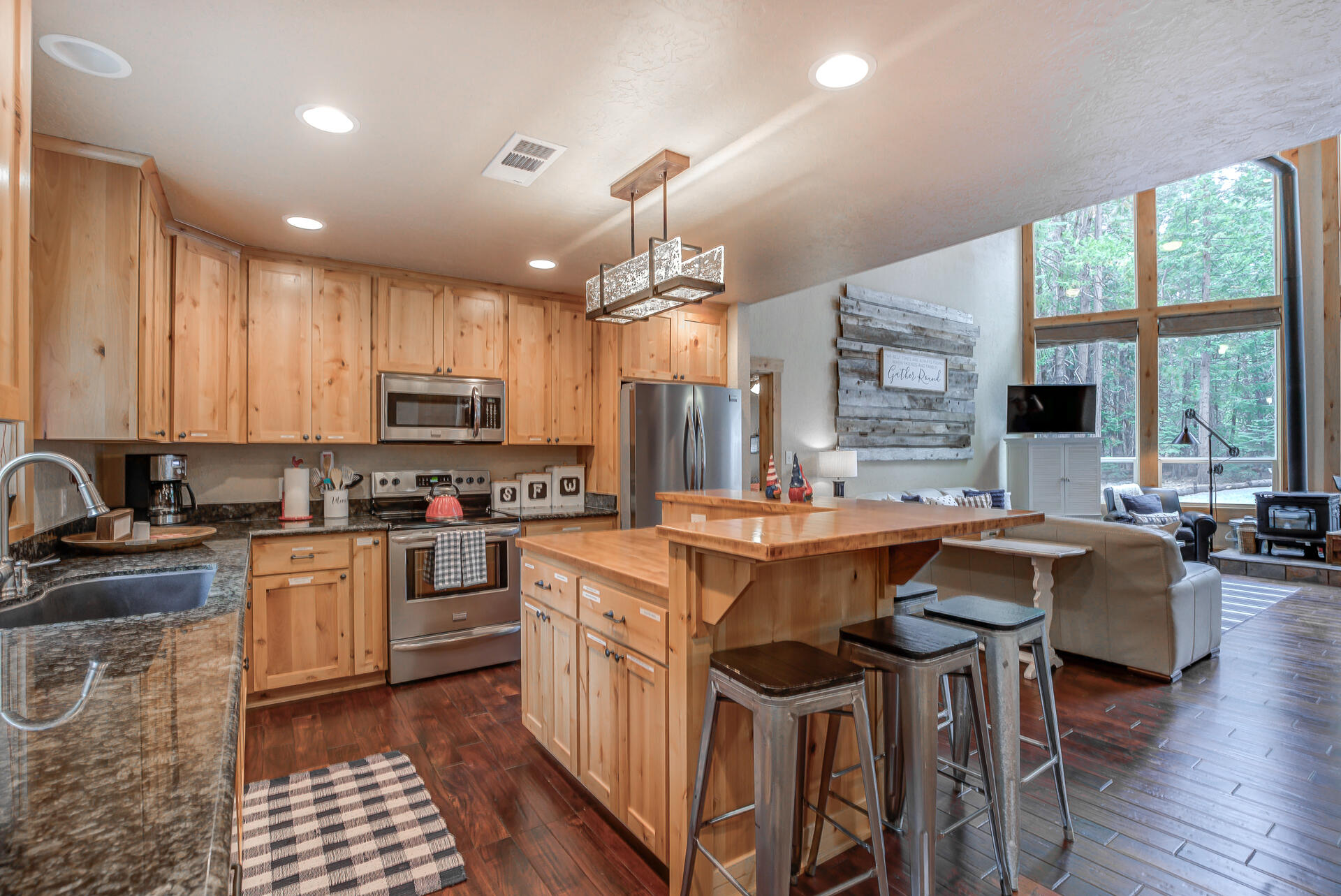 34607 Mountain Haven Road Shingletown, CA 96088 - Photo 15 of 63 a kitchen with kitchen island granite countertop a table chairs stove a sink dishwasher and cabinets with wooden floor
