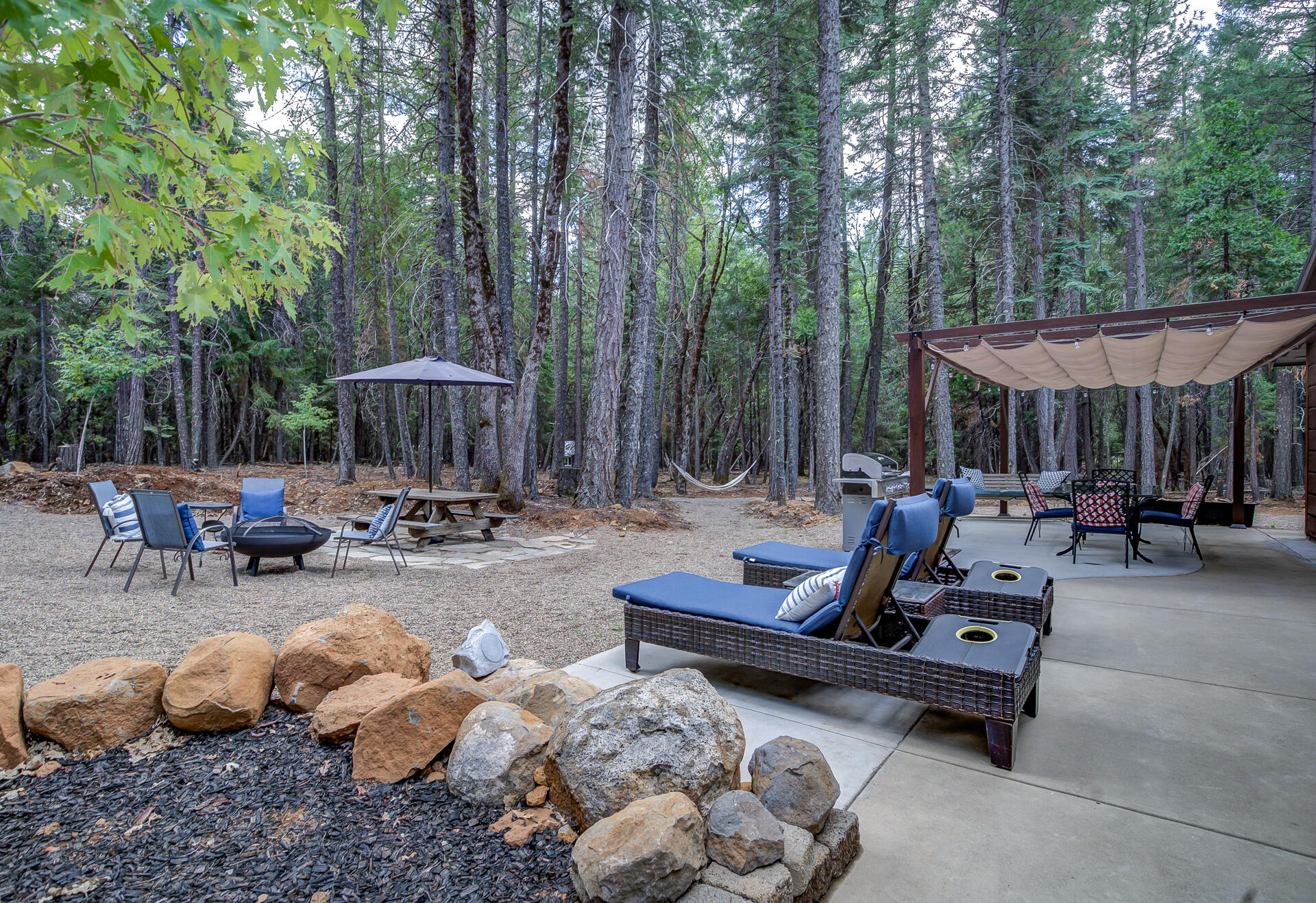 34607 Mountain Haven Road Shingletown, CA 96088 - Photo 39 of 63 a view of a patio with table and chairs potted plants and large tree