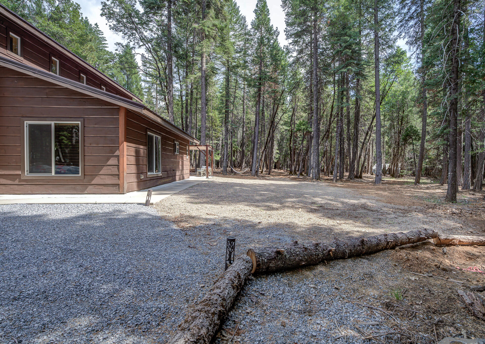 34607 Mountain Haven Road Shingletown, CA 96088 - Photo 54 of 63 a backyard of a house with large trees and a wooden fence