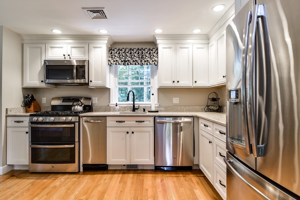 9 Longmeadow Road Medfield, MA 02052 - Photo 11 of 31 a kitchen with stainless steel appliances granite countertop a stove a sink and a microwave