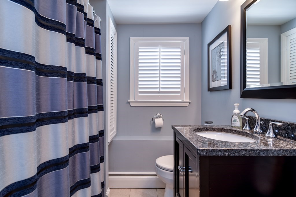 9 Longmeadow Road Medfield, MA 02052 - Photo 21 of 31 a bathroom with a granite countertop sink toilet a mirror and shower