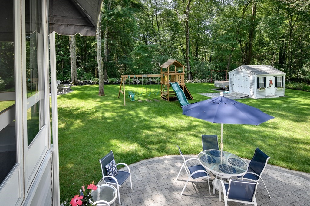 9 Longmeadow Road Medfield, MA 02052 - Photo 25 of 31 a view of a patio with a table and chairs under an umbrella