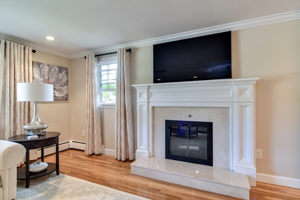 9 Longmeadow Road Medfield, MA 02052 - Photo 5 of 31 a living room with a fireplace and a flat screen tv