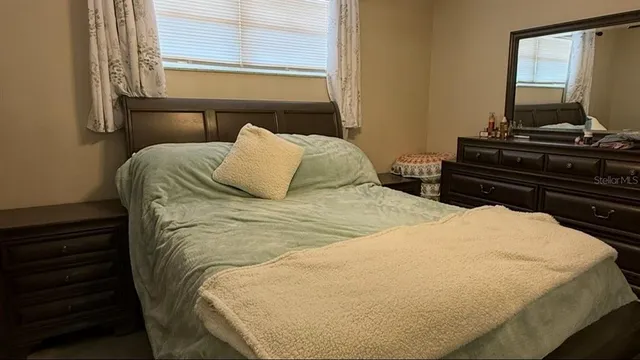 a bed sitting in a bedroom next to a window