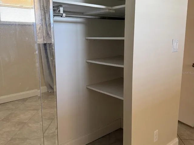 a view of walk in closet with empty racks