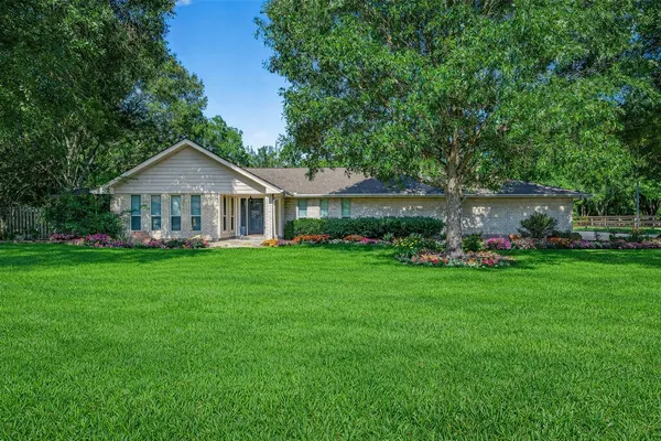 a front view of a house with a yard and green space