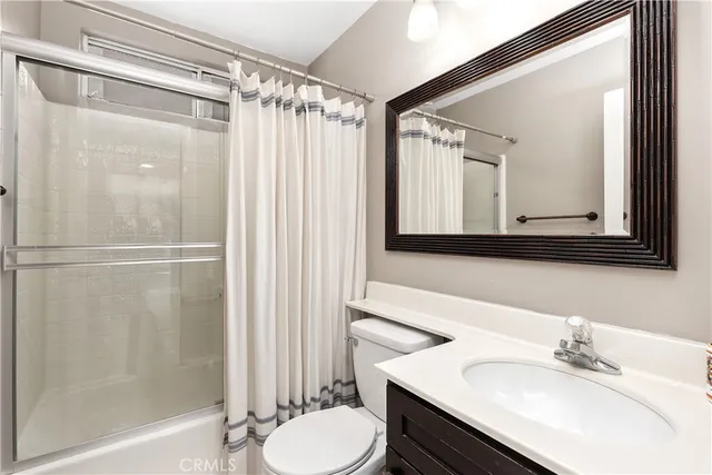 a bathroom with a sink vanity mirror and toilet