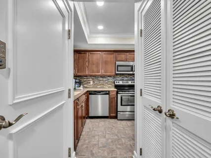 a kitchen with stainless steel appliances granite countertop a stove a sink dishwasher a refrigerator and a microwave oven with wooden floor