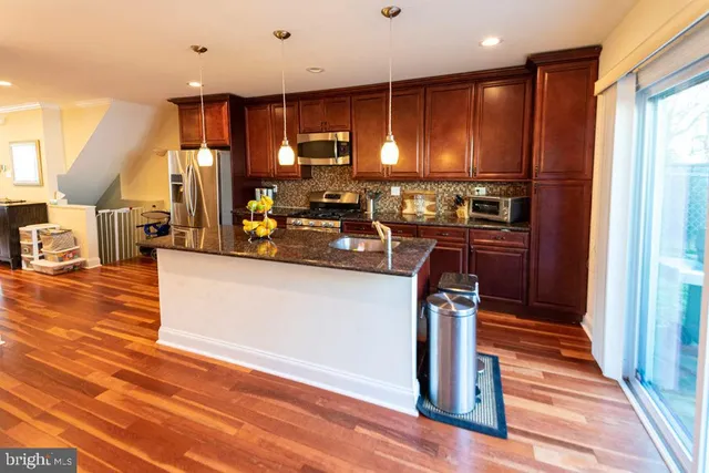 a kitchen with stainless steel appliances granite countertop a refrigerator and a stove top oven