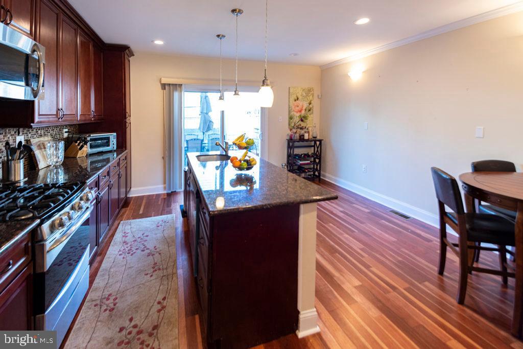 2107 Carpenter Street Philadelphia, PA 19146 - Photo 5 of 24 a kitchen with stainless steel appliances granite countertop a refrigerator a stove top oven a sink and wooden floor