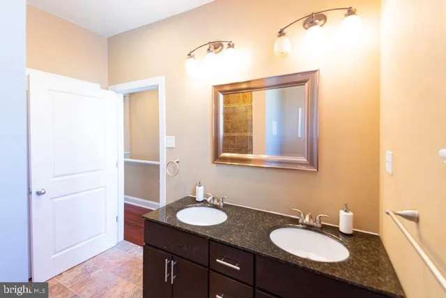 a bathroom with a granite countertop sink and a mirror