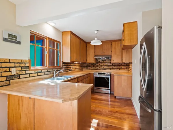 a kitchen with stainless steel appliances a refrigerator sink and cabinets