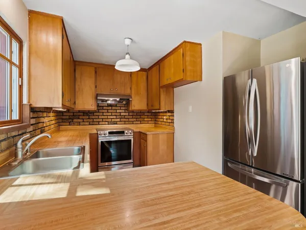 a kitchen with stainless steel appliances a stove a refrigerator and a sink