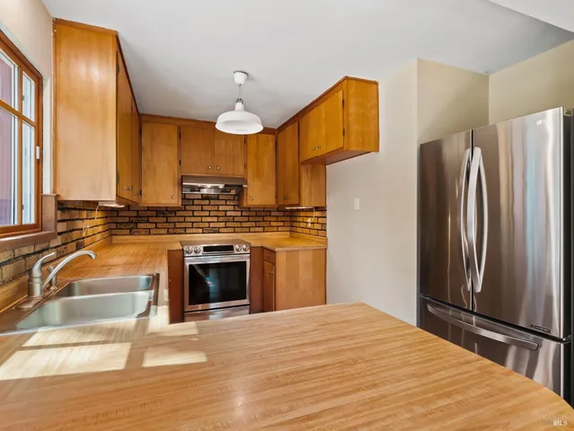 a kitchen with stainless steel appliances a stove a refrigerator and a sink