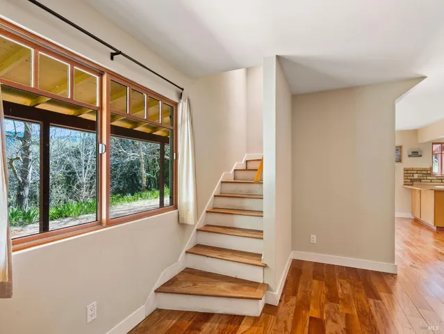 a view of entryway and hall with wooden floor