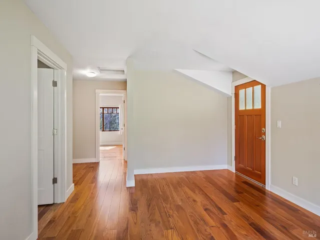 a view of an empty room with wooden floor