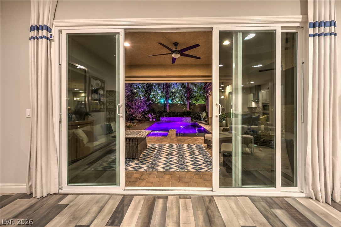 7119 Arabian Ridge Street Las Vegas, NV 89131 - Photo 8 of 73 Seamless indoor-outdoor living with a private pool and illuminated patio.