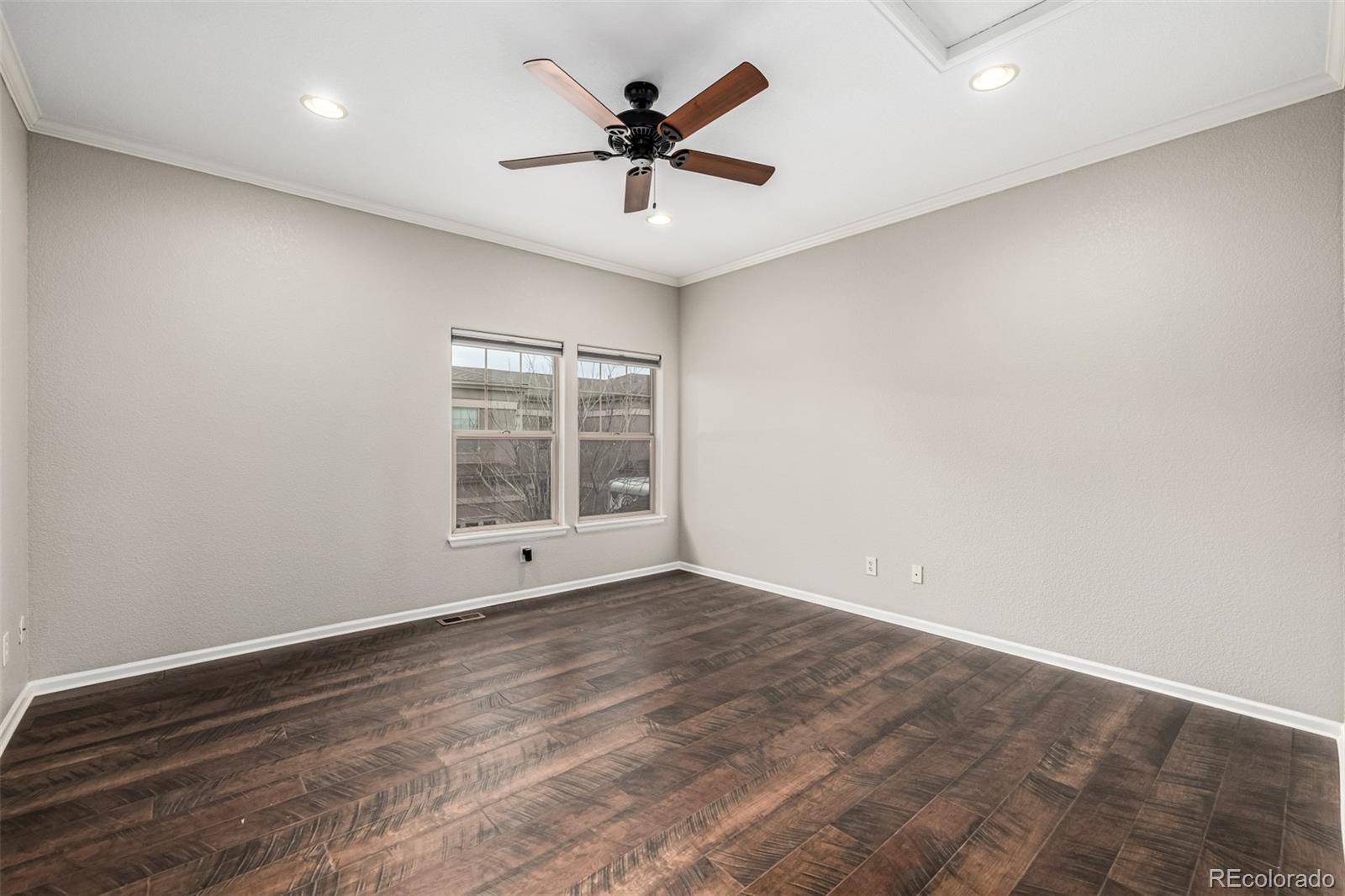 15501 East 112th Avenue, Unit 34C Commerce City, CO 80022 - Photo 12 of 18 an empty room with wooden floor and ceiling fan