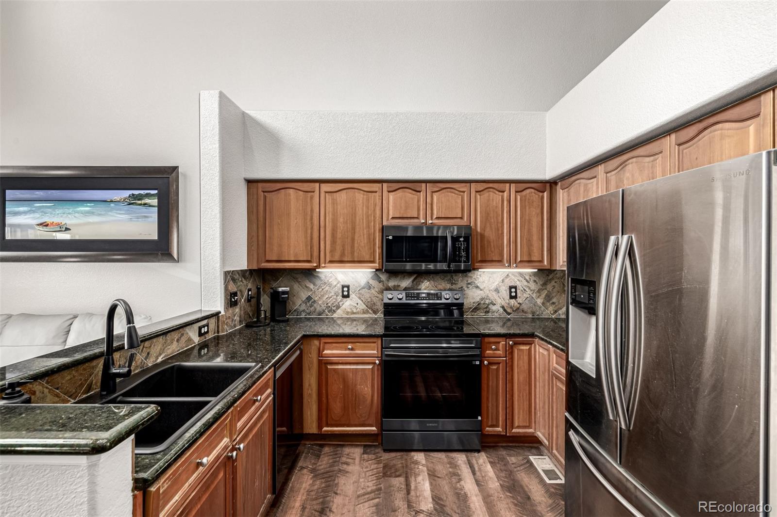 15501 East 112th Avenue, Unit 34C Commerce City, CO 80022 - Photo 7 of 18 a kitchen with stainless steel appliances a sink stove and refrigerator