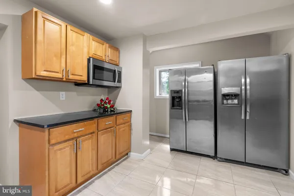 a kitchen with stainless steel appliances granite countertop a refrigerator and a stove top oven