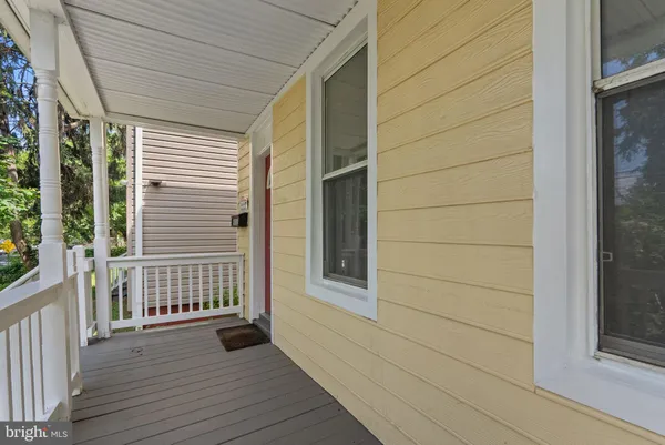 a view of a porch with wooden floor and a gate