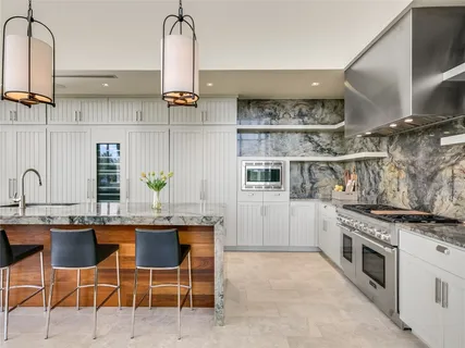 a kitchen with stainless steel appliances granite countertop a sink stove and cabinets