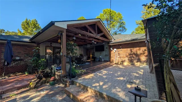 a view of a backyard with table and chairs under an umbrella with a small yard