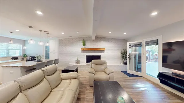 a living room with furniture a flat screen tv and a fireplace