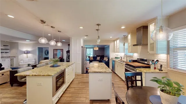 a large kitchen with kitchen island a stove a sink a dining table and chairs