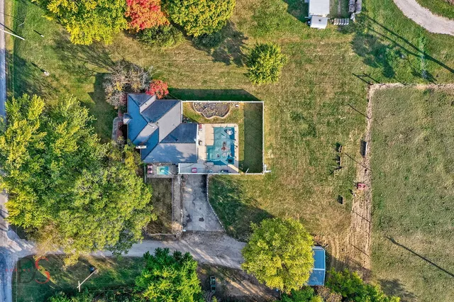 a view of a brick house with a yard and plants