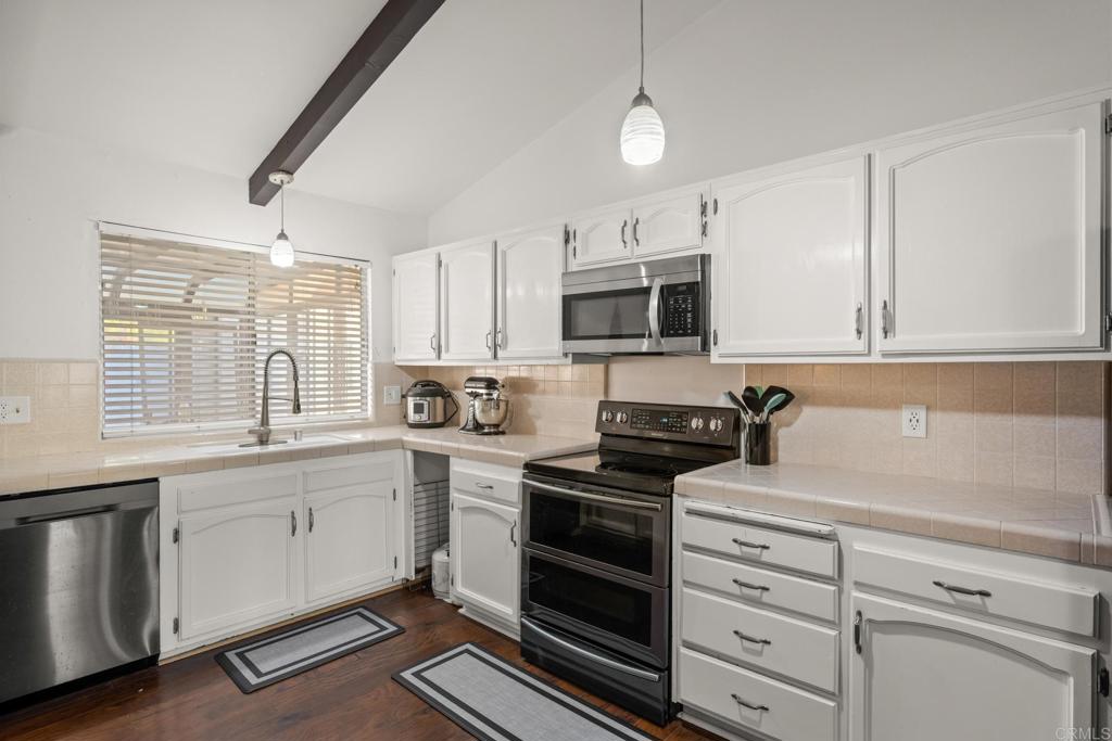 16273 Arena Drive Ramona, CA 92065 - Photo 17 of 67 a kitchen with granite countertop white cabinets and stainless steel appliances