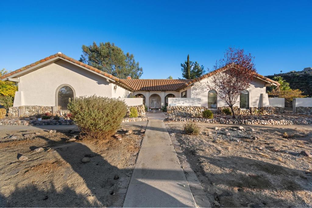 16273 Arena Drive Ramona, CA 92065 - Photo 54 of 67 a view of a white house with a yard and potted plants