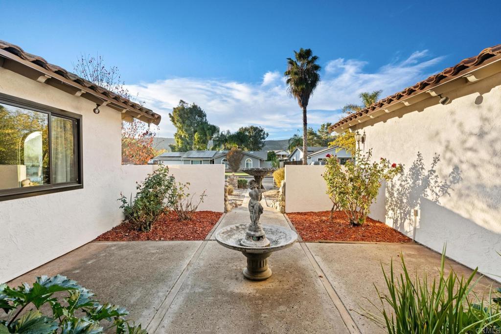 16273 Arena Drive Ramona, CA 92065 - Photo 62 of 67 a vase of flowers sitting on a floor next to a yard