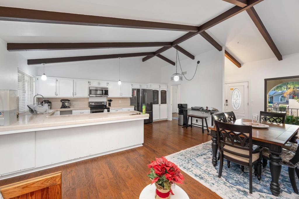 16273 Arena Drive Ramona, CA 92065 - Photo 9 of 67 a living room with stainless steel appliances furniture a rug and a dining table