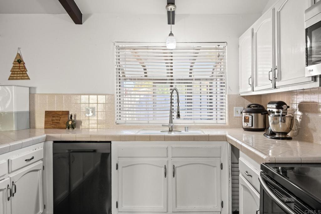 16273 Arena Drive Ramona, CA 92065 - Photo 10 of 67 a kitchen with granite countertop a sink and a white wooden cabinets