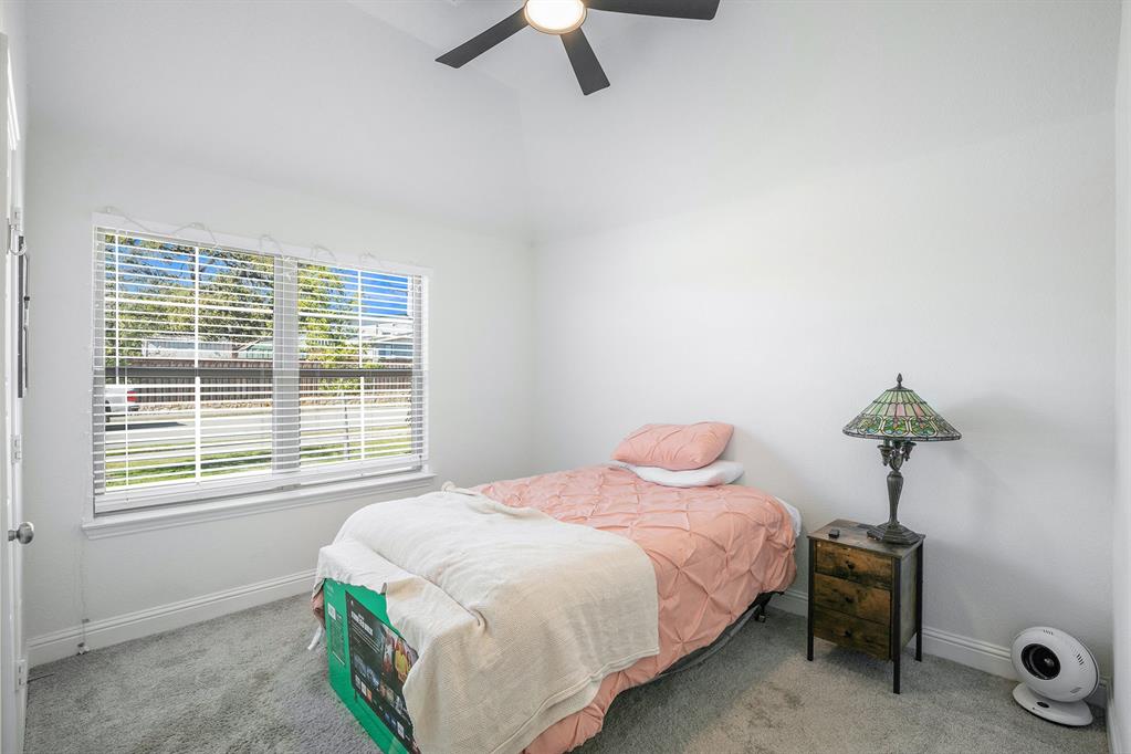 417 Elyse Road Keene, TX 76059 - Photo 14 of 17 a bedroom with a bed and a chandelier